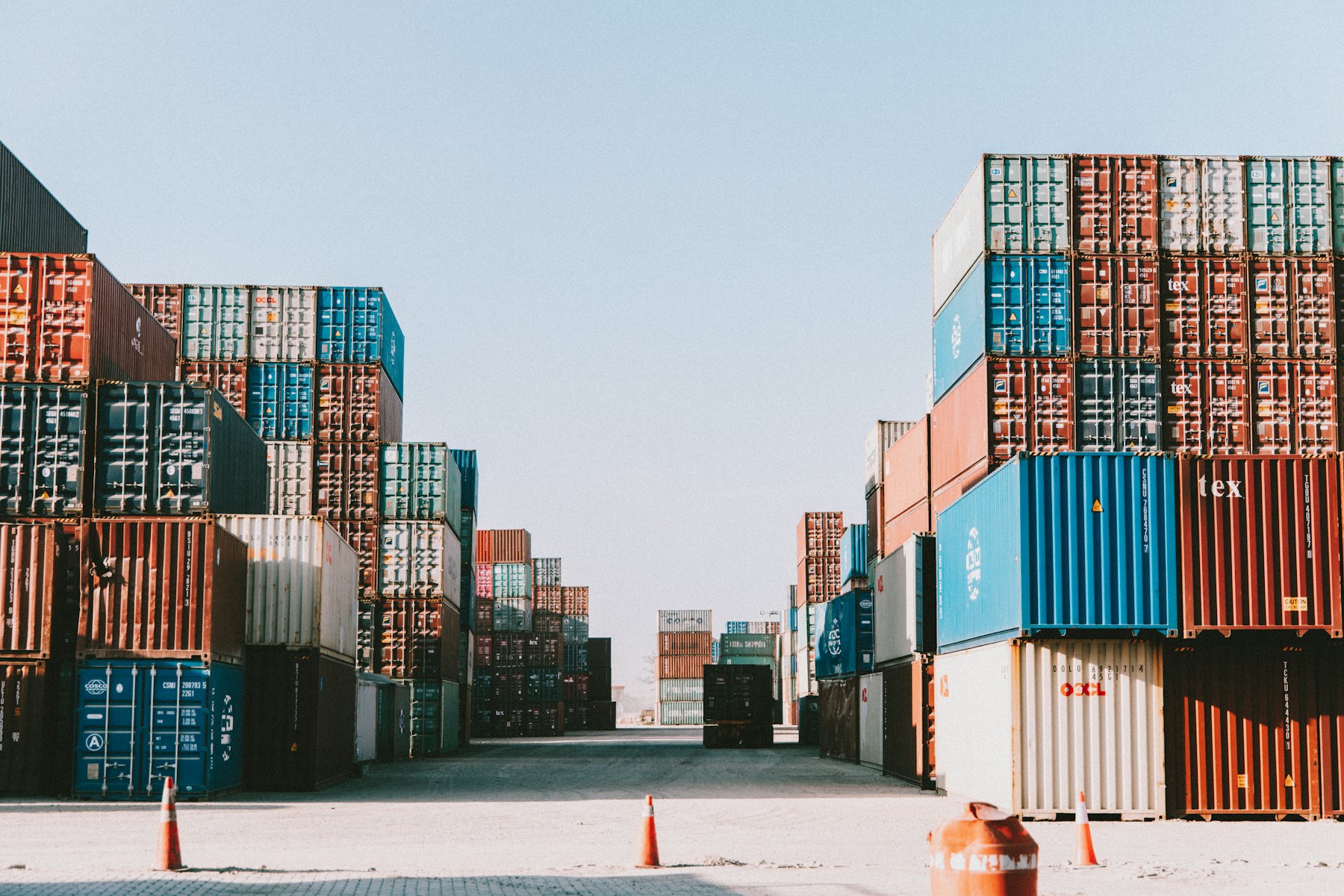 Rows of stacked shipping containers in a terminal yard.